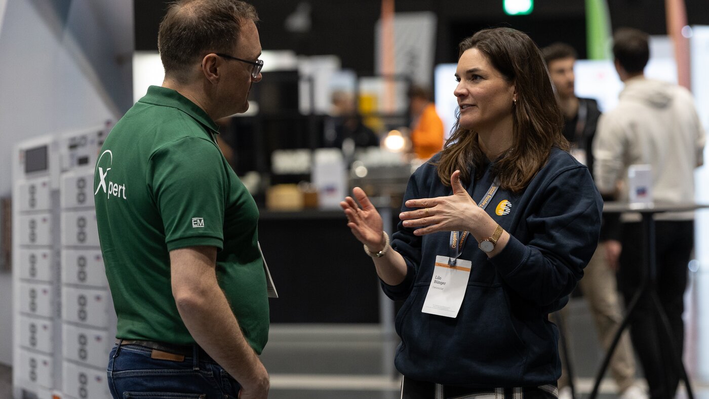 Eine Frau mit blauen Shirt und ein Mann mit grünem Shirt | © Swissolar / Sarah Bollmann