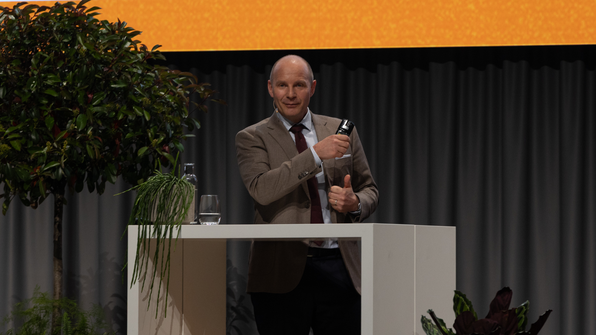 Mann mit braunem Jacket hinter weissen Stehtisch | © Swissolar / Sarah Bollmann